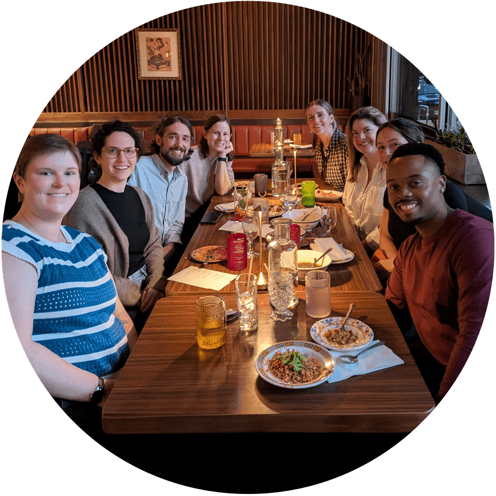 A group of 8 Onward employees sitting at a table in a restaurant for a group meal